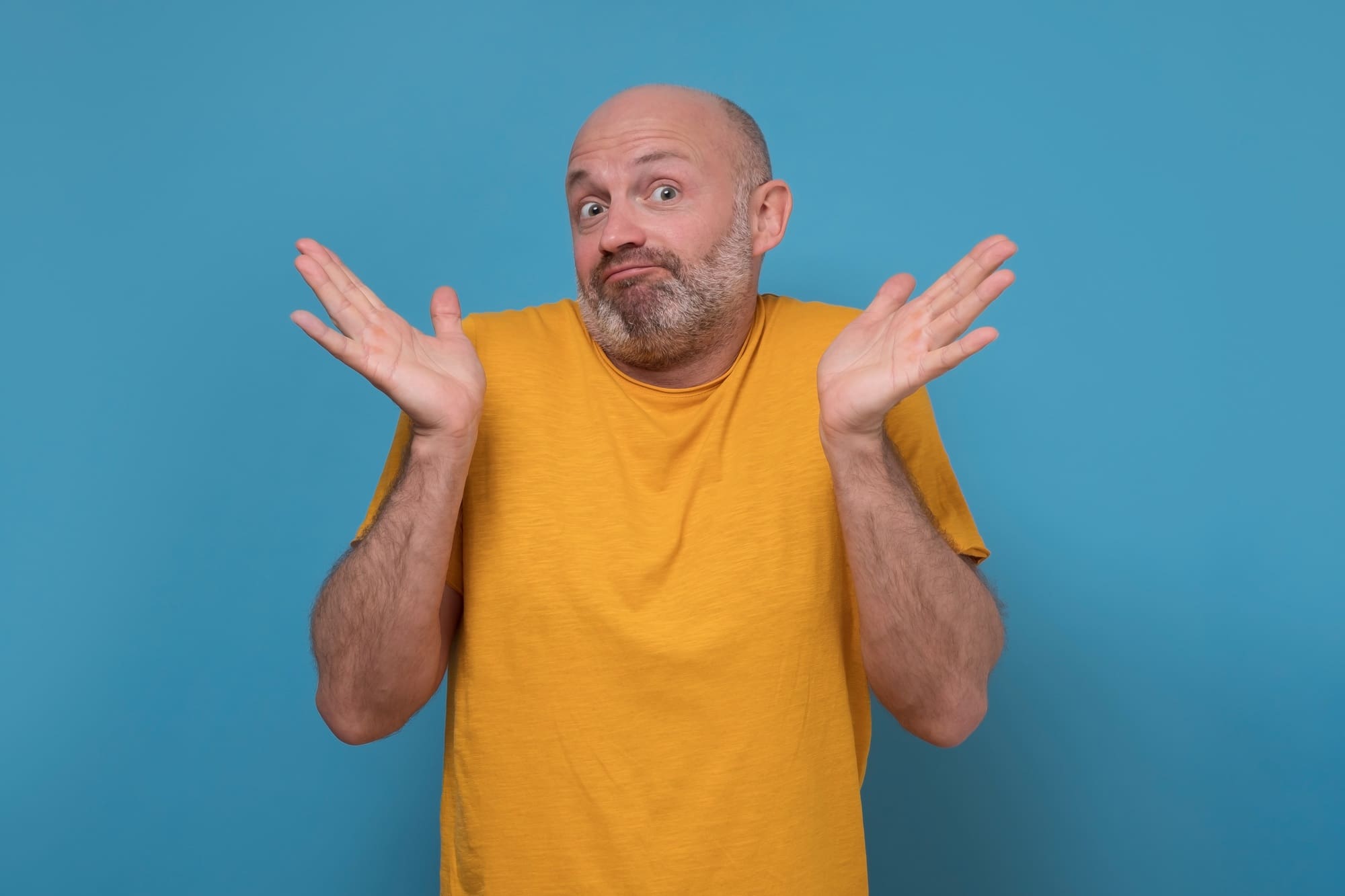 Doubtful man feel at loss lift hands in confusion unsure about problem.