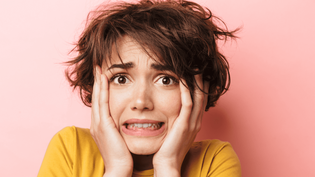 אישה במבט מודאג מחזיקה את פניה - מבטאת בלבול וחוסר ודאות לגבי אפקטיביות הדרכה בארגון